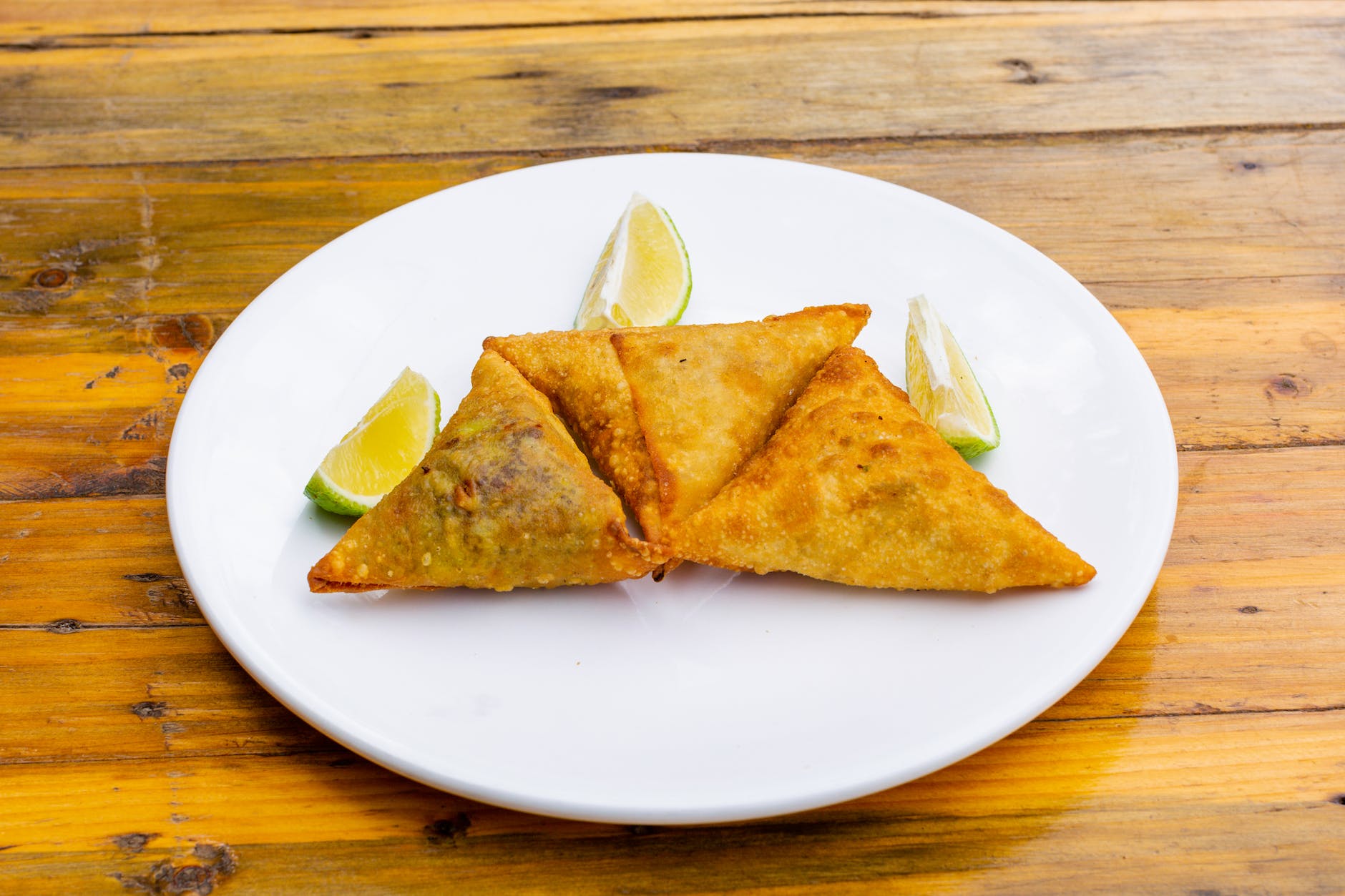 fired samosa dish on plate on wooden table